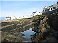 Houses above a rocky shore where the High Street and Lon Traeth Llydan meet