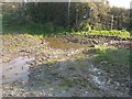 The waterlogged junction of two paths and the tarred road