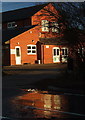 Stapleford Abbotts village hall reflected on a wet road