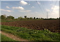 Pylons and recently ploughed field