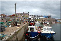 NU2232 : The inner harbour at Seahouses with the town beyond by Andy F