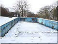 Snow covers the empty swimming pool