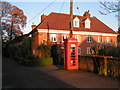 Telephone box and house in the setting sun