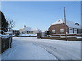 Approaching the junction of  a snowy Littlepark Avenue and Ashwood Close