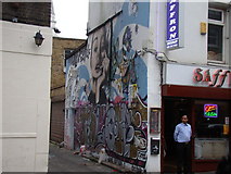 TQ3381 : Graffiti and murals on the side of Saffron Indian Takeaway by Robert Lamb