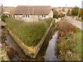 SY7083 : Sutton Poyntz: thatched cottage and streams by Chris Downer