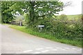 Signpost by the hedge 