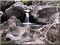 NN2835 : Interaction of water and rock in the bed of Allt Ghamhnain near Tyndrum by ian shiell