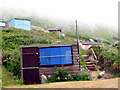 SY6873 : Beach huts and low cloud - Chesil Cove by Sarah Smith