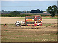 Old double-decker bus parked in field