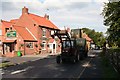 Tractor with big bales passes the Reindeer Inn