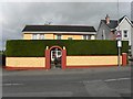 House with archway entrance and tall hedge, Clady