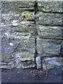 Weathered benchmark on North Street wall