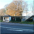 Partly-hidden postbox next to a footbridge, The Downs