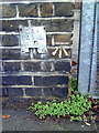 Benchmark on wall pier outside Sherington Primary School