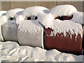 Snow-covered recycling bins