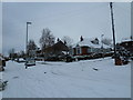 Approaching the crossroads of a snowy  Solent Road and Uplands Road