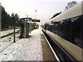 A snowy down platform at Holton Heath station