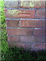 Benchmark on garage block in centre of Underhill Circus