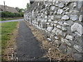 Wall alongside Lighthouse Road, and a bench mark