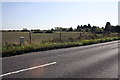 View across A338 including milestone