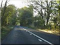 B4077 bounded by trees near Flagstone Farm