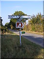 TM3956 : Snape Road to Snape & the roadsign at the Crossroads by Geographer