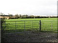 View across farmland to a farm off Longstone Hill