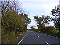 TM4071 : The A144 and the entrance to Coopers Wood by Geographer