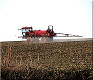TM2759 : Crop spraying in field south of Session Wood, Easton by Evelyn Simak