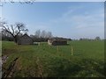 A modern farm building and one which is ruined