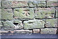 Benchmark on the wall of Addison Street