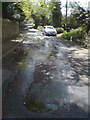 Road near Tite Tap, with spring water welling through tarmac