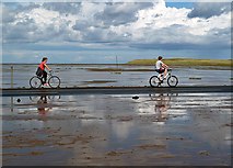 NU0943 : Cyclists on Lindisfarne Causeway by Walter Baxter