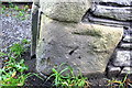 Weathered benchmark on Middleham Moor Road wall