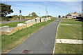 Rock wall separating Reap Lane from path past houses