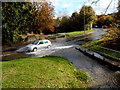 Car splashes through a minor flood on Henbury Road, Bristol