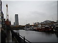 View of a restored harbour crane, Wharfside Point South, Anderson House and Tower Hamlets Town Hall from Poplar Dock