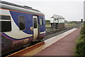 A Carlisle-bound  train and signal box at Maryport station