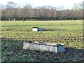 Cattle troughs in a muddy pasture field