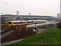 TQ3577 : Train passing the site of a future new station by Stephen Craven