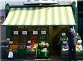 Putting up the blind at the greengrocer