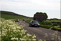 SK1075 : Field barn and minor road on Wormhill Moor by Graham Hogg