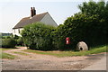 Post box and a mill stone at Cotes Grange Farm