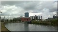 View of flats on Stratford High Street, the Arcelo-Mittal Orbit sculpture and an old factory chimney from the Lea Navigation