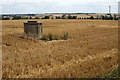 Tall manhole in a stubble field