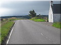 The A832 heading south past a roadside cottage