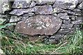 SD6198 : Benchmark on rock in wall beside A685 by Roger Templeman