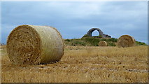 NX4842 : Straw bales and the 'eye' of Cruggleton Castle ruin by Jonathan Billinger