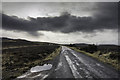 NH5639 : Bleak road over moorland by Peter Moore